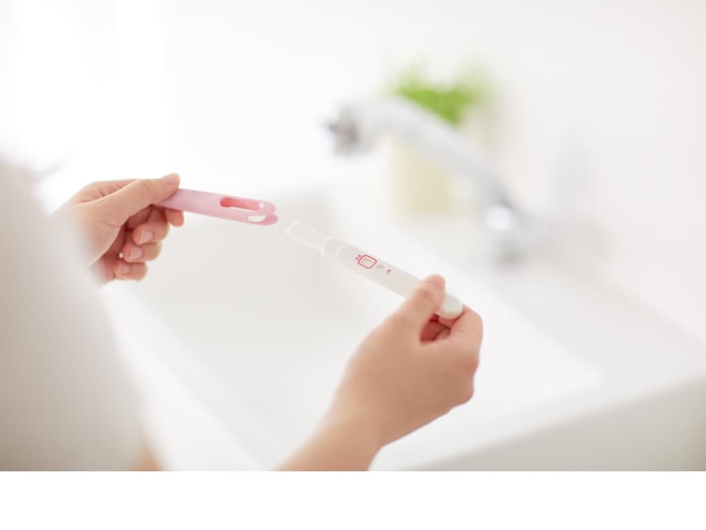 Woman checking pregnancy urine test